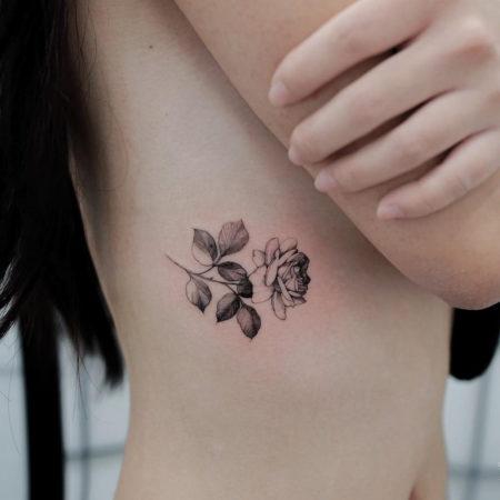 Женское тату в стиле минимализм цветы на боку